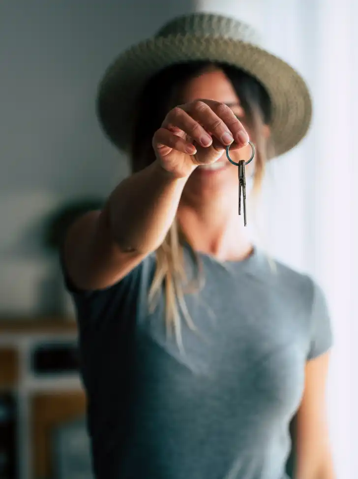 Portrait of female tenant renter showing keys