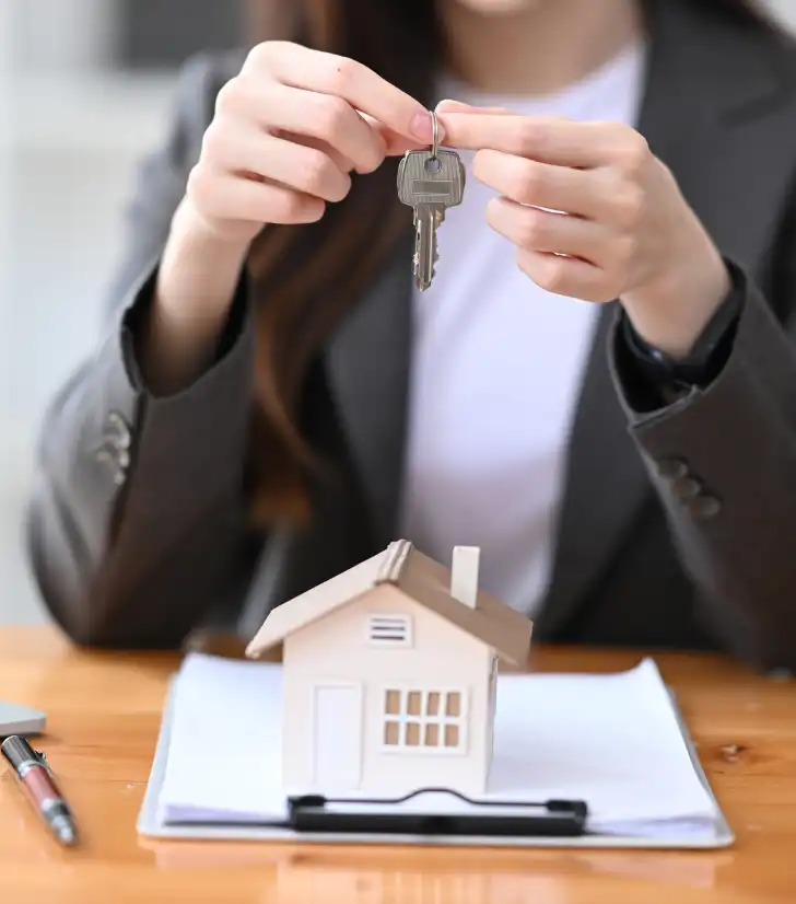 Smiling real estate agent holding house keys